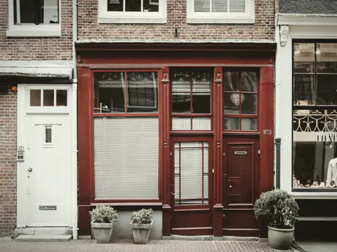 The shopfront: oxblood woodwork and one big window